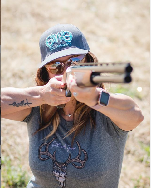Person holding a rifle in an outdoor setting